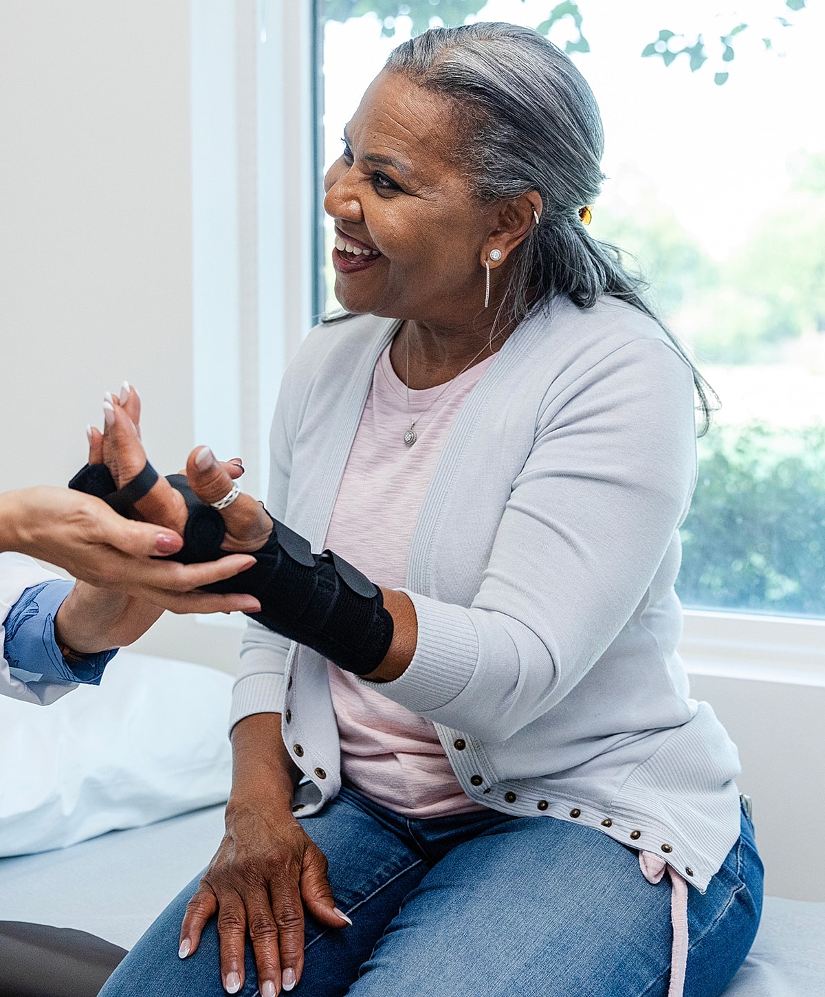 Woman smiling during hand therapy session.