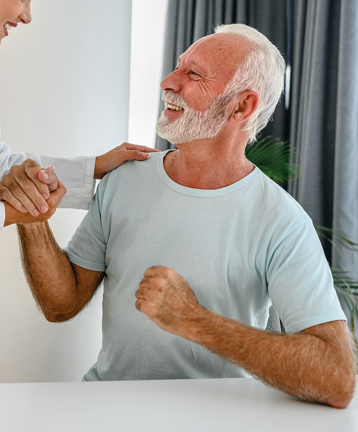 Happy elderly man celebrating with caregiver.