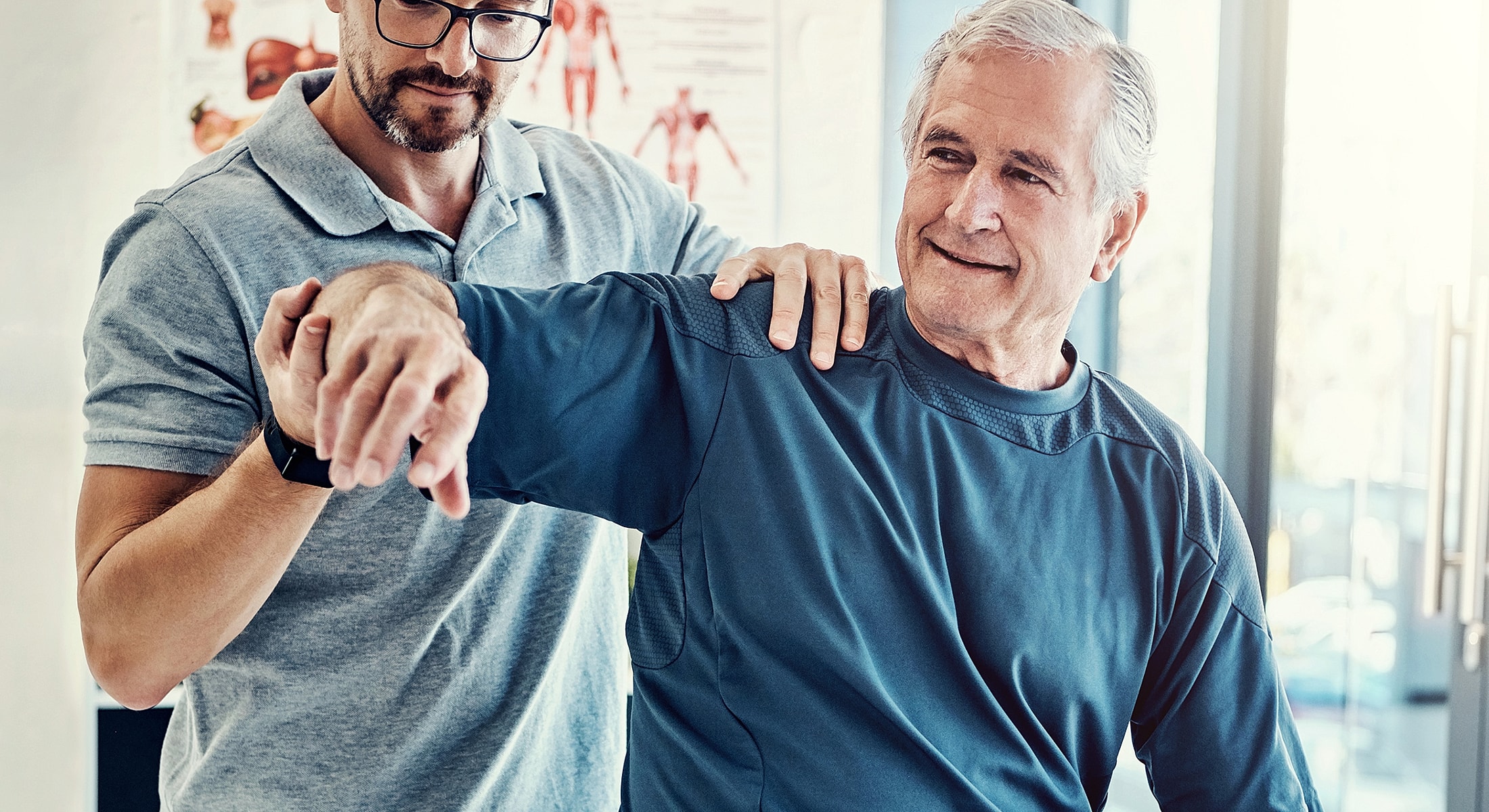 Therapist assisting senior with arm rehabilitation exercise.