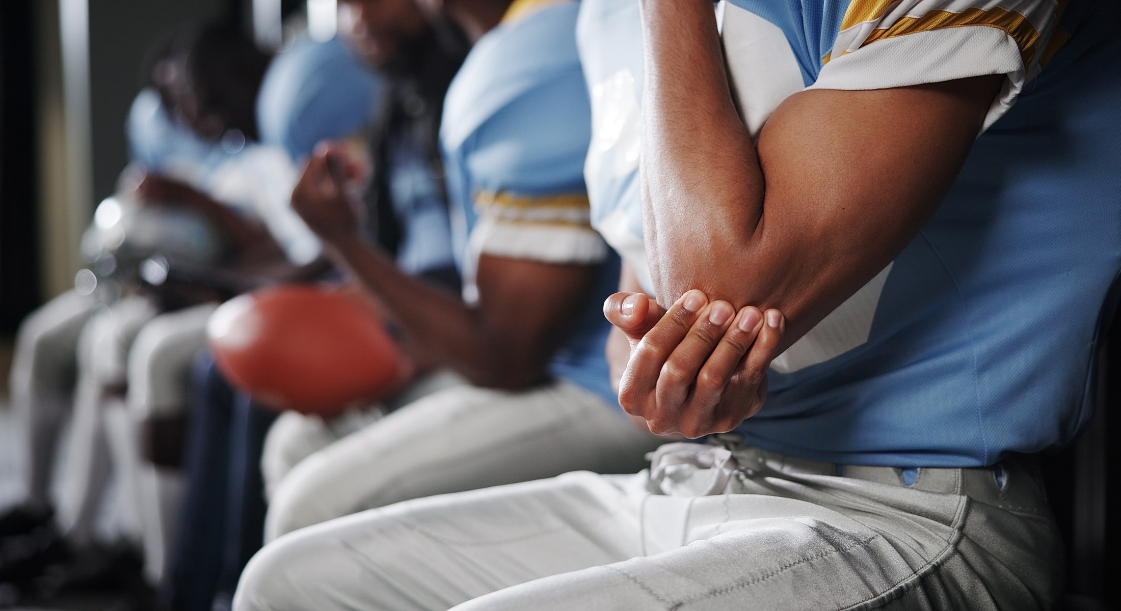 Football players sitting and preparing for game.